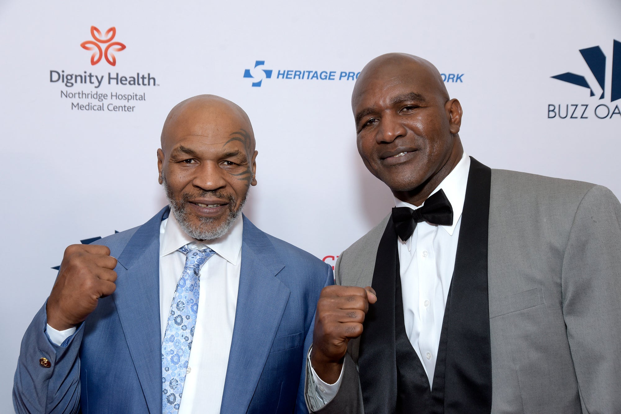 Evander Holyfield ‍and Mike⁤ Tyson face‍ off in a boxing ring.