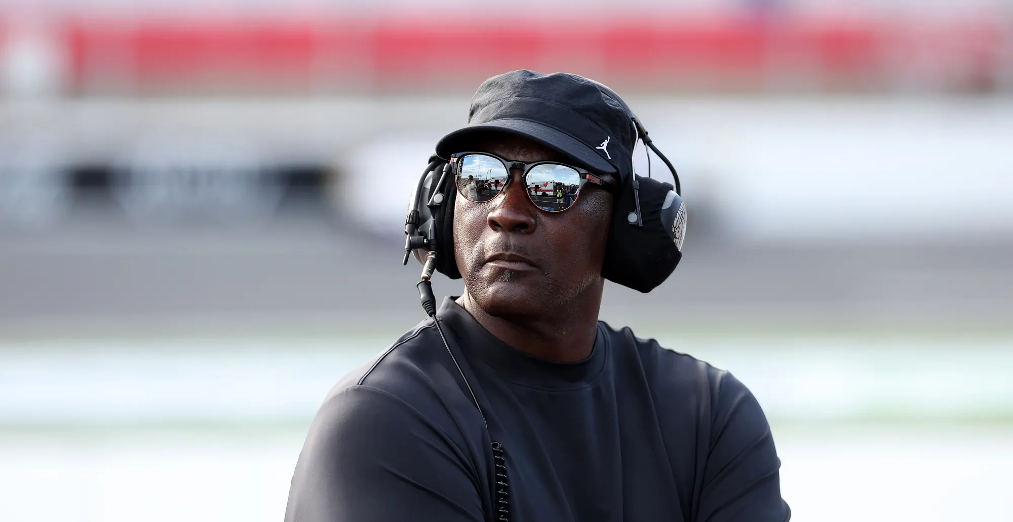 Michael Jordan, NBA Hall of Famer and co-owner of 23XI Racing listens to the race on pit road during the NASCAR Cup Series Bank of America ROVAL 400 at Charlotte Motor Speedway on October 05, 2025 in Concord, North Carolina.