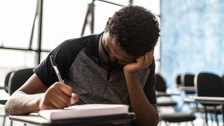 Tired student in the classroom - wearing face mask
