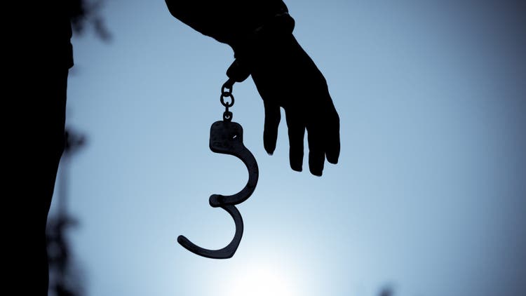 Cropped Hand Of Men Removing Handcuffs