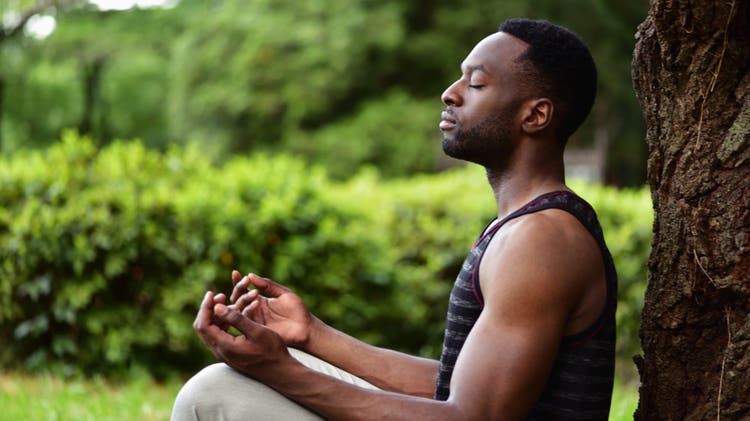 Young man meditating, focusing on mental health