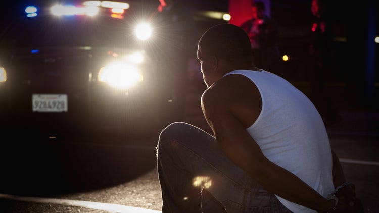 Black person being detained by police
