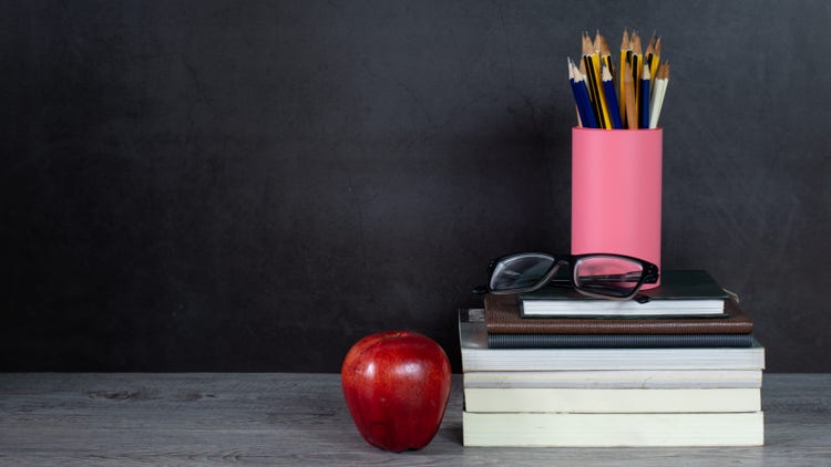 books with pencils and apple