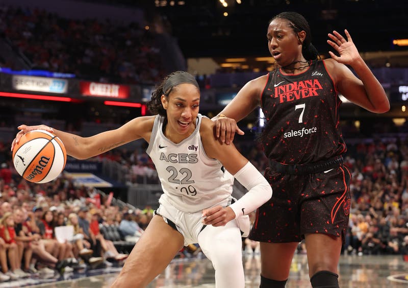 A'ja Wilson #22 of the Las Vegas Aces dribbles the ball while defended by Aliyah Boston #7 of the Indiana Fever