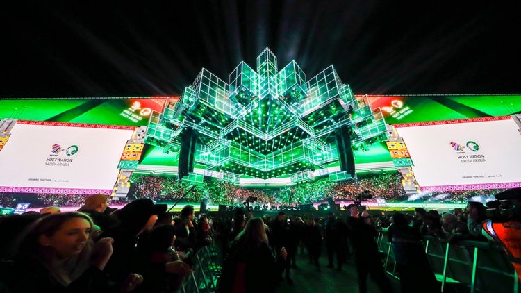 A large screen with lights and people in the background AI-generated content may be incorrect.