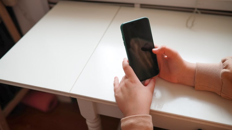 A person holding a phone Description automatically generated